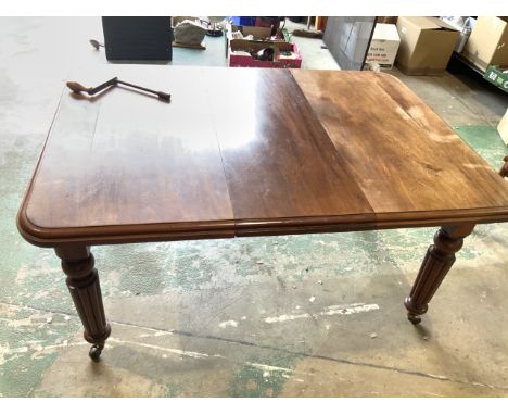 A small early 20th century mahogany dining  table on large brass and ceramic castors with extra leaf and winder. W:143cm x D: