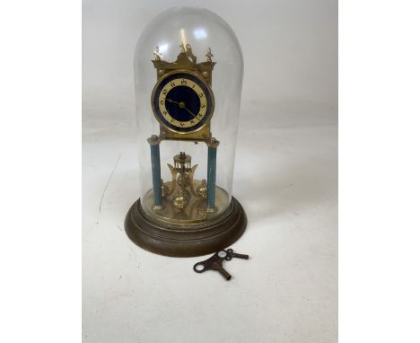 A brass anniversary clock with blue enamel face, glass  dome, two keys.W:19cm x H:30cm