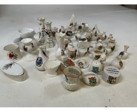 A large collection of crested ware including a Teepee, a donkey, a tank, a helmet a yacht and others