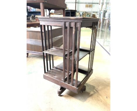 A 20th century revolving bookcase with ceramic castors. W:46cm x D:46cm x H:86cm