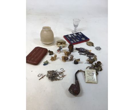 A quantity of interesting items including an ornate pipe, a leather holder, Wade whimsies, brass buttons, a clock work pengui