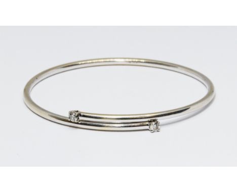 An 18ct gold diamond bangle, the two round brilliant cut diamonds weighing approx. 0.10cts each, hallmarked 18ct white gold, 