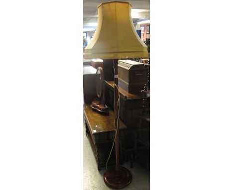 Modern mahogany standard lamp with shade on circular base.