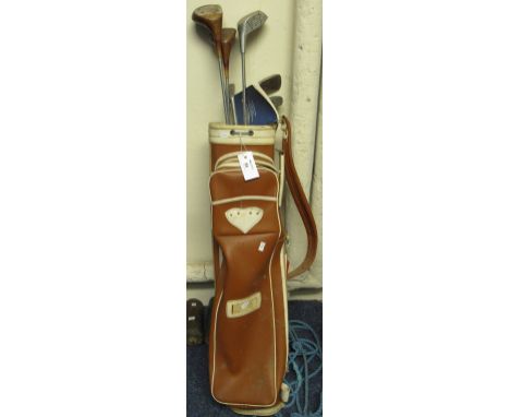 Vintage golf bag containing assorted clubs to include a One three wood and mixed irons.