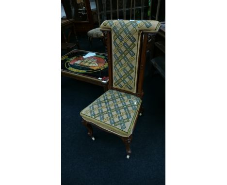 A mahogany framed unholstered prayer chair resting on cabriole supports and ceramic castors.