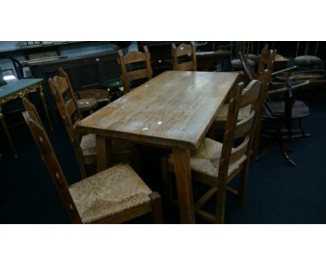 A large French oak farmhouse dining table together with six matching ladder back oak framed chairs with string drop-in seat p