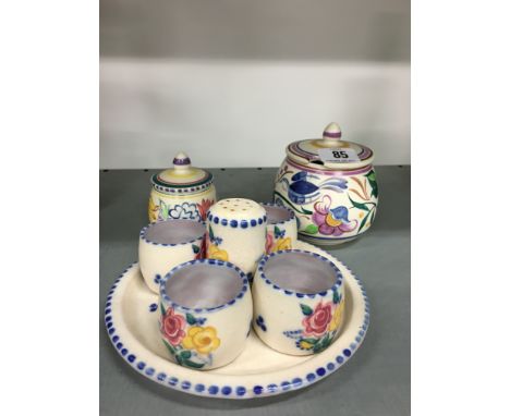 A Poole Pottery four egg cup set decorated in the BF pattern together with a plate, pepper pot and two lidded pots.