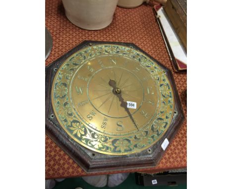 A brass compass on oak mount.