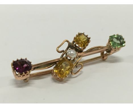 An antique yellow metal brooch set with various gemstones and a pearl.
(R10)