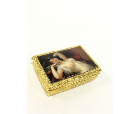 A gilded metal and enamel snuff box with risque lid decorated with a reclining nude female.