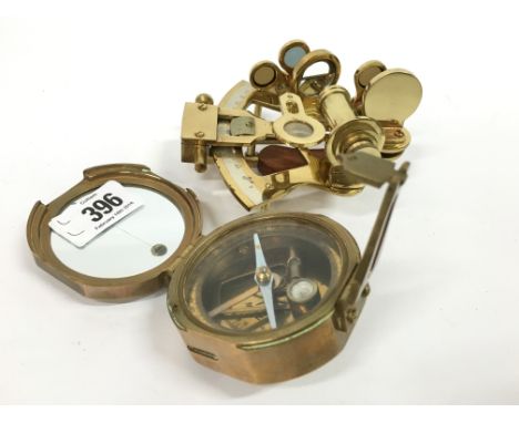 A reproduction folding brass compass together with a reproduction brass sextant.
