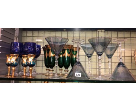 SHELF OF BLUE ETCHED AND GREEN GILDED GLASS GOBLETS