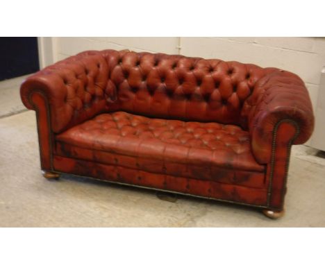 A circa 1900 buttoned red leather upholstered chesterfield scroll arm sofa on squat bun feet 163 cm wide x approx. 88 cm deep