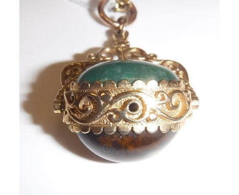 A 9 carat gold mounted pendant set with swivel caboshon cut tiger's eye and jade beads on an associated chainlink necklace 