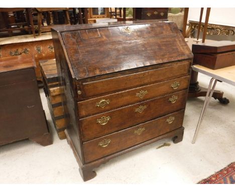 An 18th Century North Country oak bureau, the sloping fall enclosing a stepped fitted interior with well, over three long dra