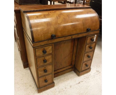 A 19th Century mahogany cylinder bureau, the plain top with reeded edge over a plain cylinder with ebonised handles opening t