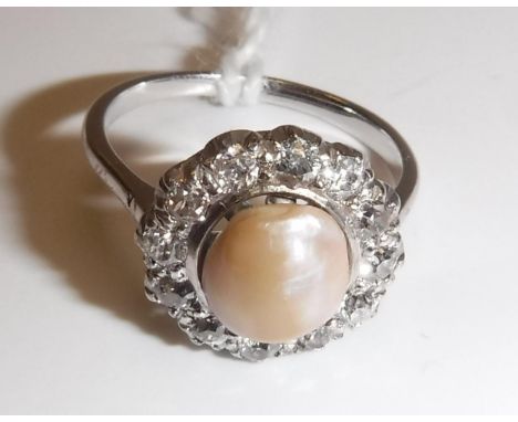 A white gold mounted pearl and diamond dress ring, the central pearl (approx size 8), within a band of twelve small diamonds,