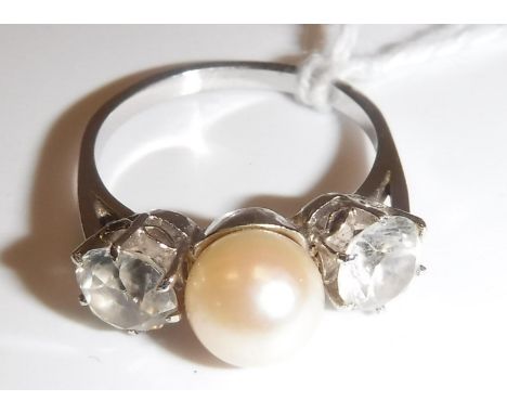 A white gold mounted (un-marked) pearl and white sapphire dress ring, the central pearl (approx size 9) flanked by two diamon