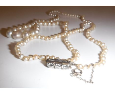 A natural saltwater pearl single strand necklace with diamond clasp, each of the three stones approx .1 carat, 153 graduated 