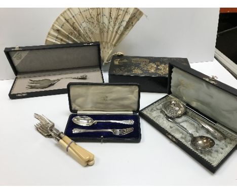 A collection of silver and silver plate cutlery to include a cased continetal white metal serving fork, a cased silver spoon 