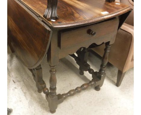 A 19th Century oak oval gate-leg drop-leaf dining table in the 17th Century manner, the top with moulded edge over end drawer