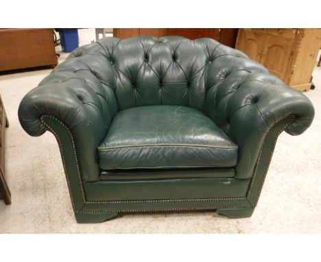 A pair of green buttoned leather upholstered scroll arm chairs with studded show frame front on bracket feet, 110 cm wide x 9
