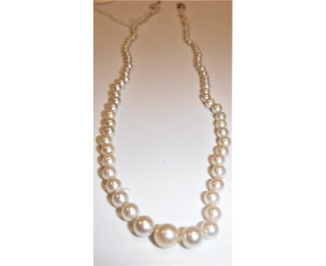 A graduated pearl single strand necklace with 18 carat white gold and platinum diamond mounted clasp set with two stones, eac