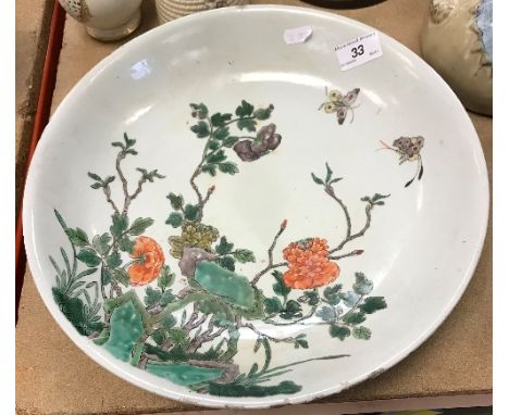 A 19th Century Chinese famille-verte circular dish with blossoming foliage and butterfly decoration, raised on a circular foo