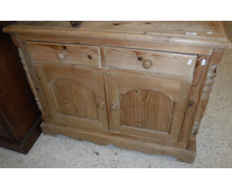 A modern Continental pine side cabinet, the top with moulded edge over two drawers and two cupboard doors on a bracket foot b