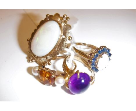 A collection of four various 9 carat gold mounted rings including an oval cabochon cut opal within a foliate design the stone