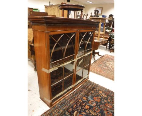 A circa 1900 mahogany display cabinet, the cornice with bobbin decorated banding over two arched astragal glazed doors enclos