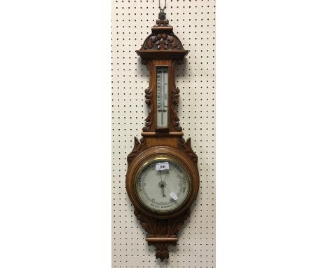 A circa 1900 carved oak framed aneroid barometer thermometer 78 cm high