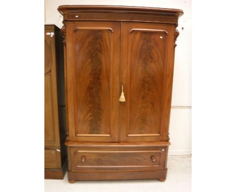 A Victorian figured mahogany wardrobe, the moulded cornice above two cupboard doors enclosing a hanging space and shelf over 