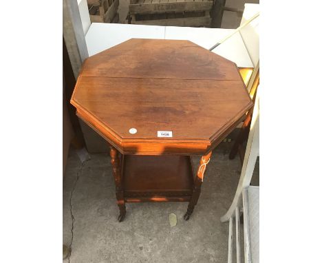 A SMALL OCTAGONAL OCCASIONAL TABLE ON CASTERS WITH LOWER GALLERIED SHELF 