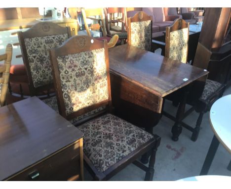 AN OAK DROP LEAF DINING TABLE WITH FOUR OAK CHAIRS WITH TAPESTRY BACKS AND SEATS 