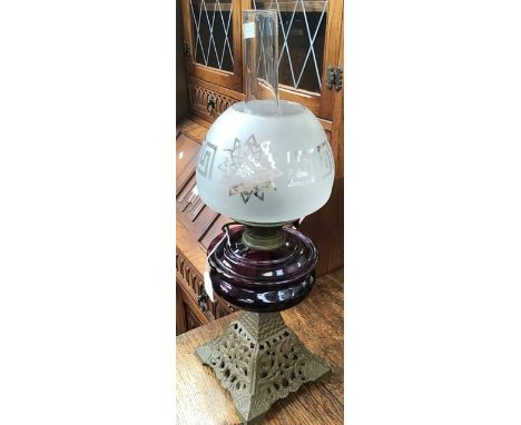 A late 19th/early 20th Century table lamp, with a frosted shade and a cranberry glass reservoir&nbsp;