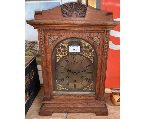 An Edwardian oak mantel clock with brass dial and chiming movement 