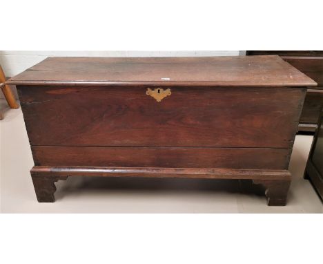 An 18th century oak blanket box with hinged lid, on bracket feet 