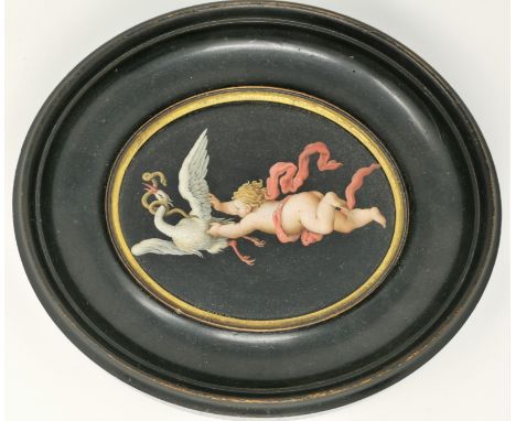 A 19th century oval ceramic plaque enamelled with putto grasping a swan, 13 x 16 cm, framed 