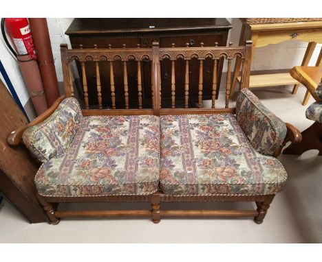 An Ercol country style two seater settee with stick back floral tapestry upholstery 