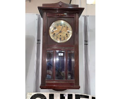 A mahogany cased wall clock with brass dial and bevelled glass 