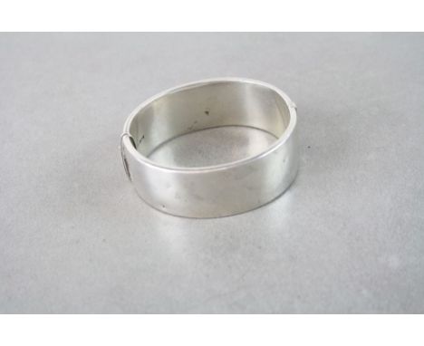 A vintage hallmarked silver cuff bangle with leaf decoration to one side.