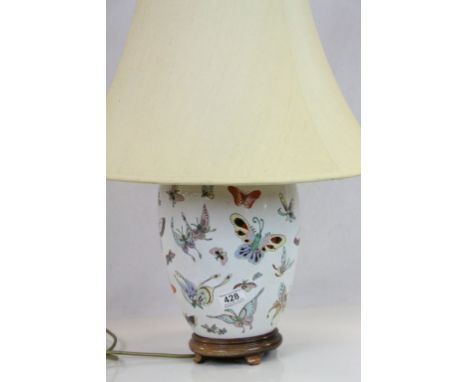 A chinese ceramic lamp base with butterfly decoration, measures approx 30cm in height excluding the shade.