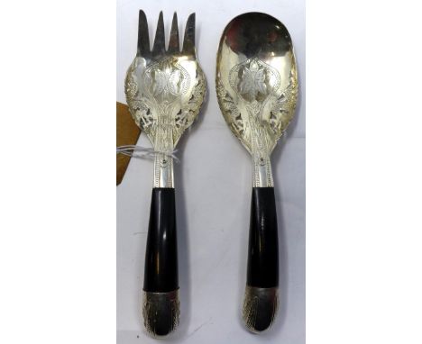 A white metal serving spoon and fork, with pierced and engraved floral decoration and ebony handles, L.21cm 