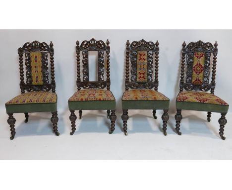 A set of four Victorian oak chairs with bobbin supports and tapestry upholstery, raised on castors 