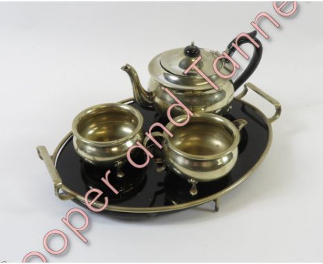 A three piece silver plated tea service, along with a serving tray with a black glass insert