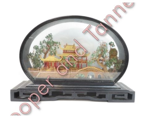 A modern Chinese model of a temple in a glass dome