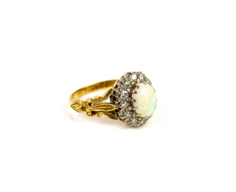 Opal and diamond cluster ring, central oval cabochon cut 9 x 7mm, set in a border of round brilliant cut diamonds, with decor