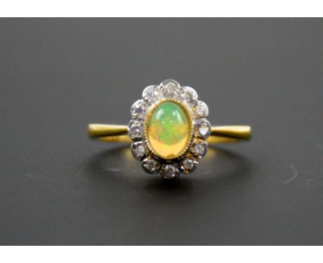 Edwardian style opal and diamond ring, central stone within a border of brilliant cut diamonds, 18 ct gold, ring size O  .   