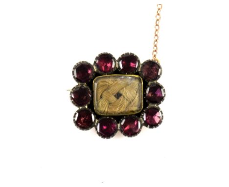 Georgian period brooch with circular flat cur garnets in a foiled back setting, central hair panel, 2 x 1.7cm, in 9 ct,  tass